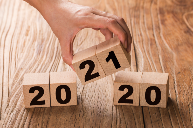 A hand holds building blocks that replace 2020 with 2021.
