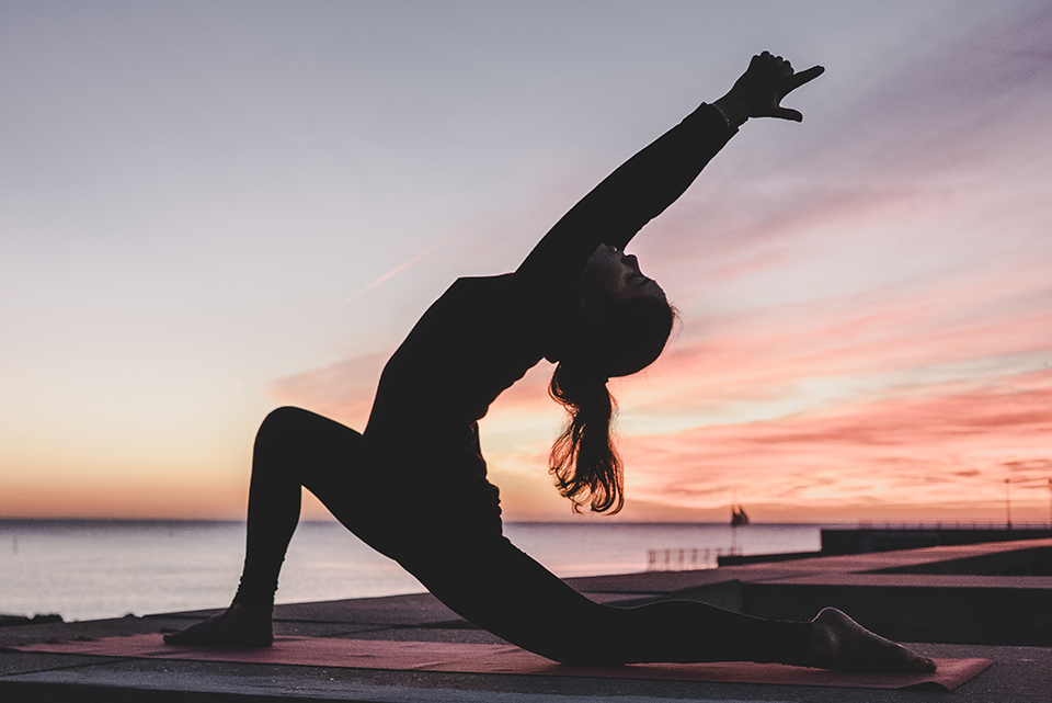 losing-weight-heart-of-wellness-washington, image of a woman stretching during a sunset