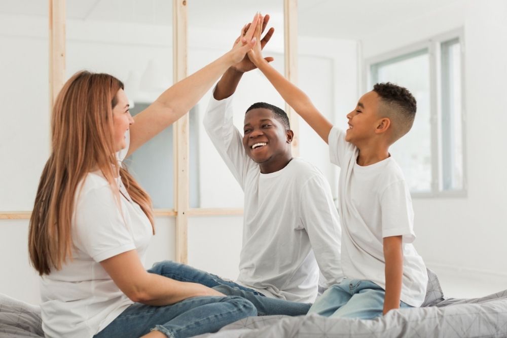 Tips for a Successful Family Meeting, image of a family high-fiving together
