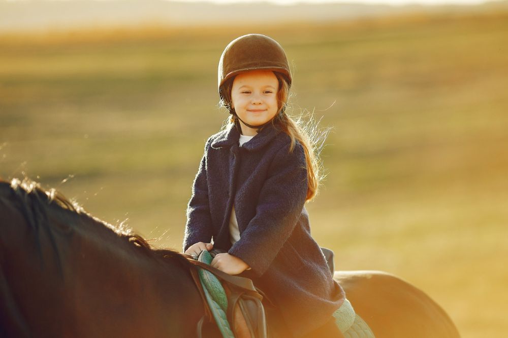 Image of a little girl smiling while on horseback